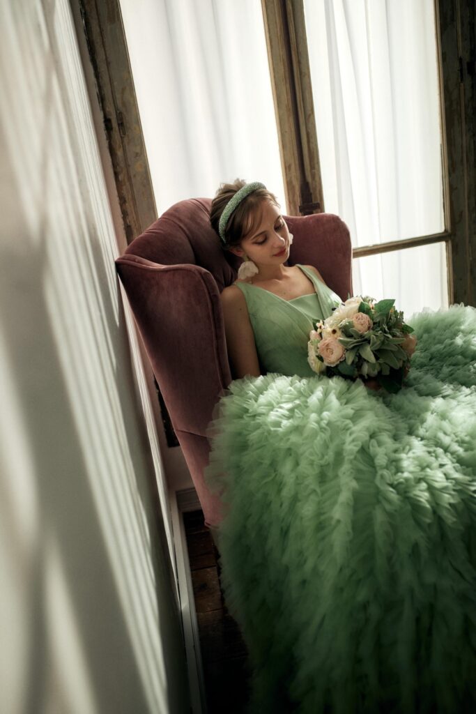 椅子に座りブーケを持つプレ花嫁様のグリーンドレス試着ショット